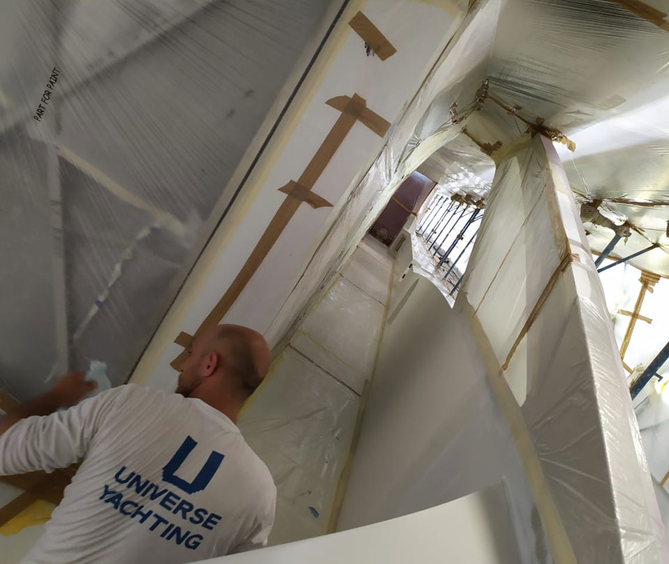 universe yachting worker preparing surface for paint